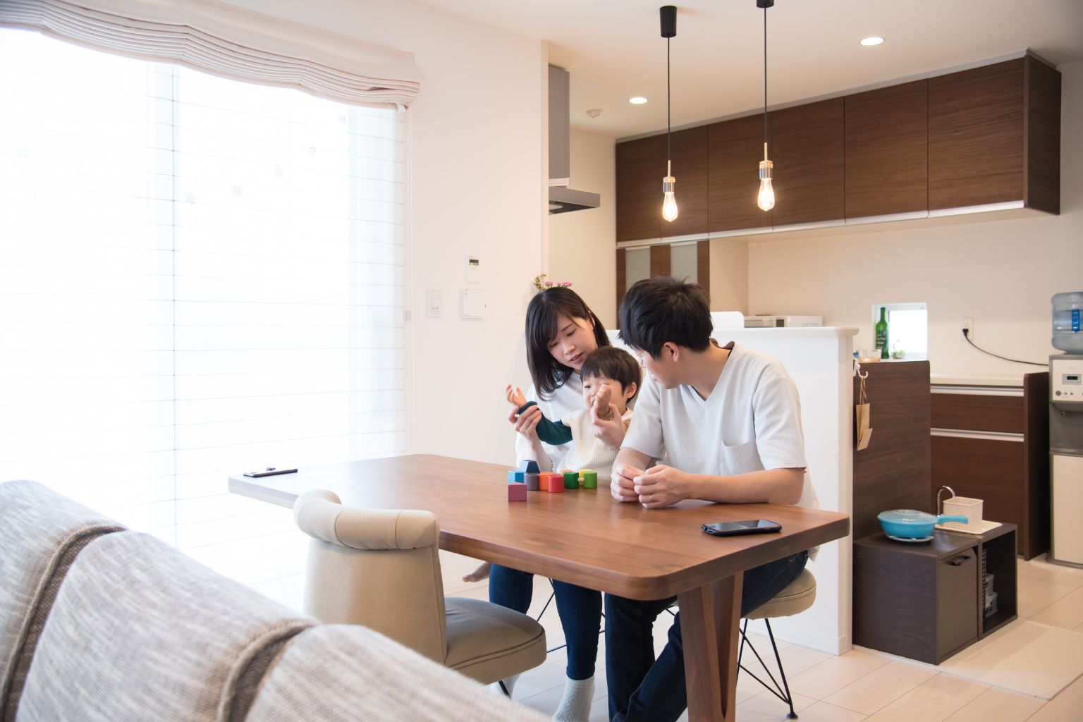 図面と素材サンプルを囲んで、住まいの希望を話し合う手元のイメージ